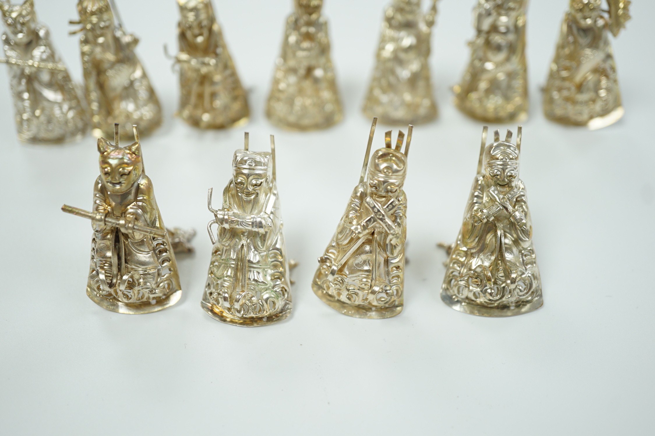 A set of eleven Chinese white metal menu card supports, in the form of artisans, 41mm.